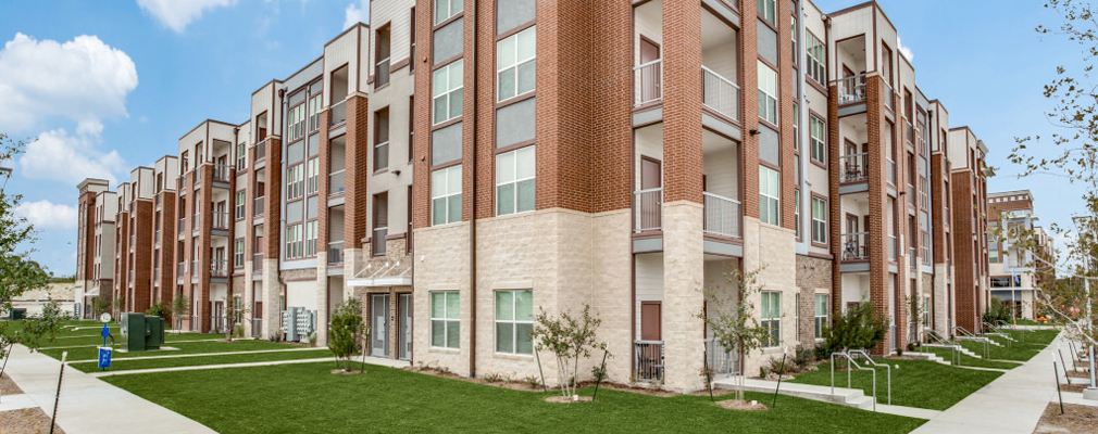  A perspective view of a four-story building fronted by green lawns.