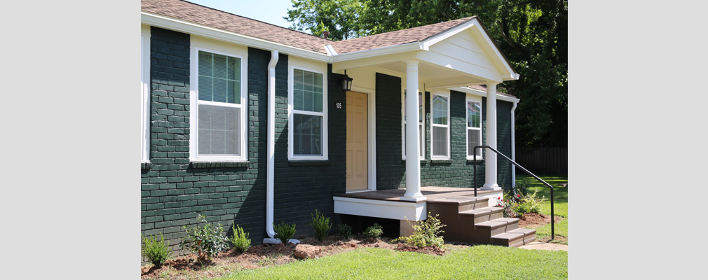 Front view of a single-story home at Harmony Village, with steps leading to a small front porch.