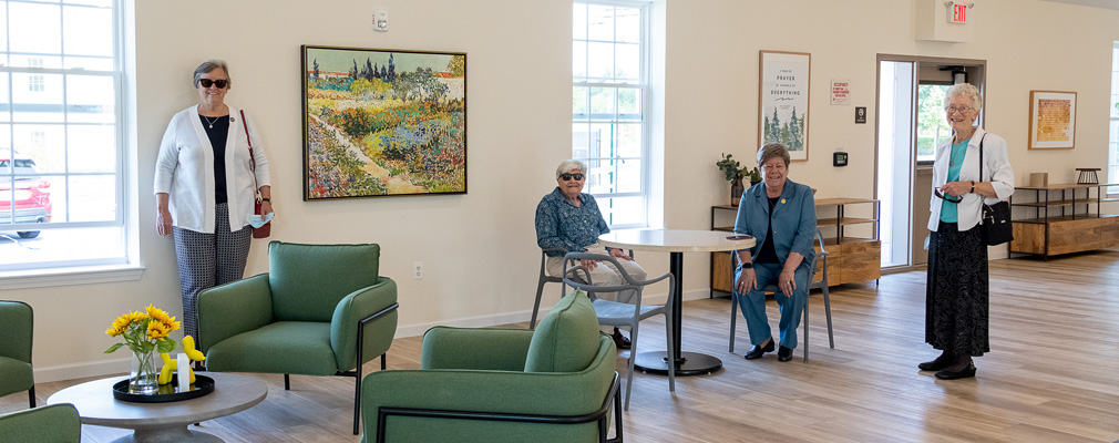 Four seniors in an apartment complex community room.