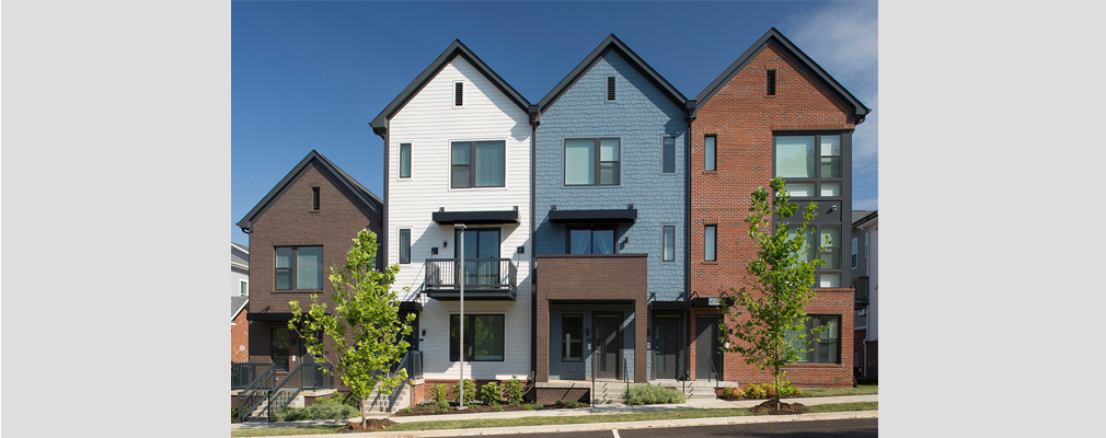 Photograph of the front façades of a 2-story and three 3-story townhouses. 