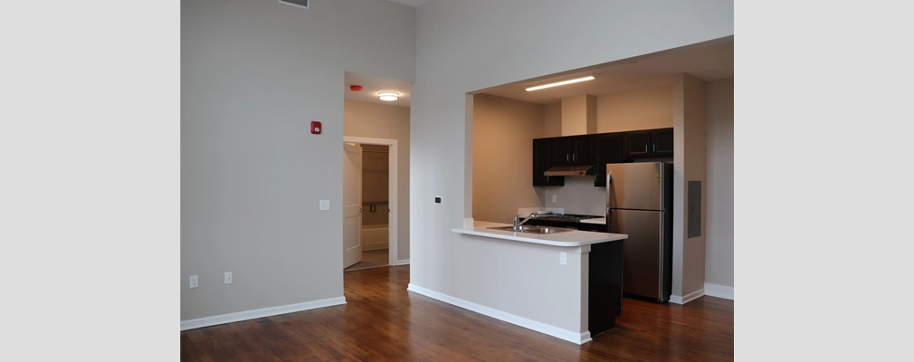 Interior of a new apartment with gray walls and wood flooring.