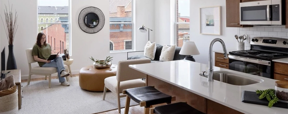 Interior of apartment kitchen and living room with seating area.