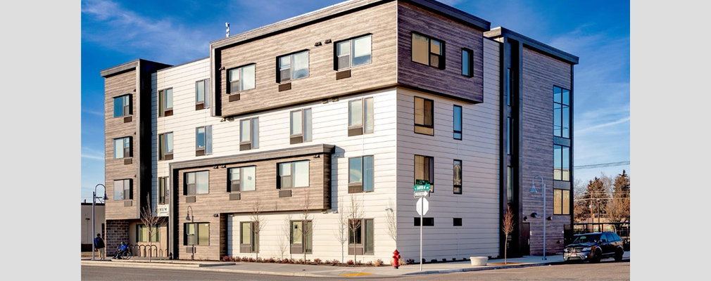 Photograph of the front and side façades of a four-story residential structure.