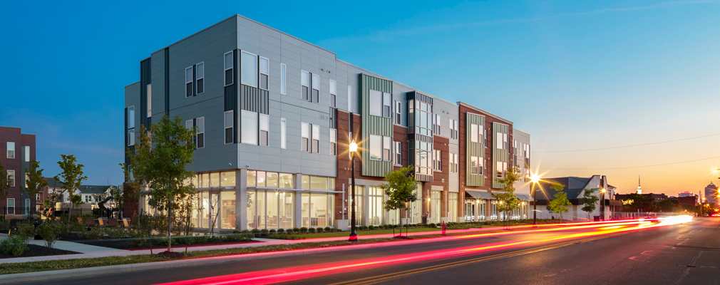 Photograph of corner view of low-rise apartment building from across an intersection.