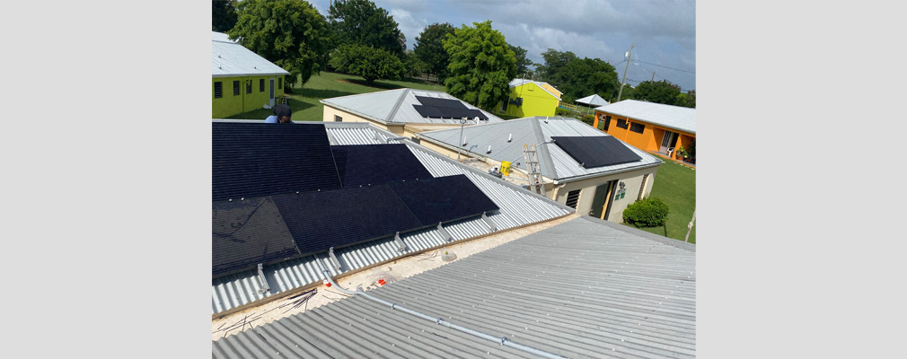 Rooftops of several neighboring structures equipped with solar panels.