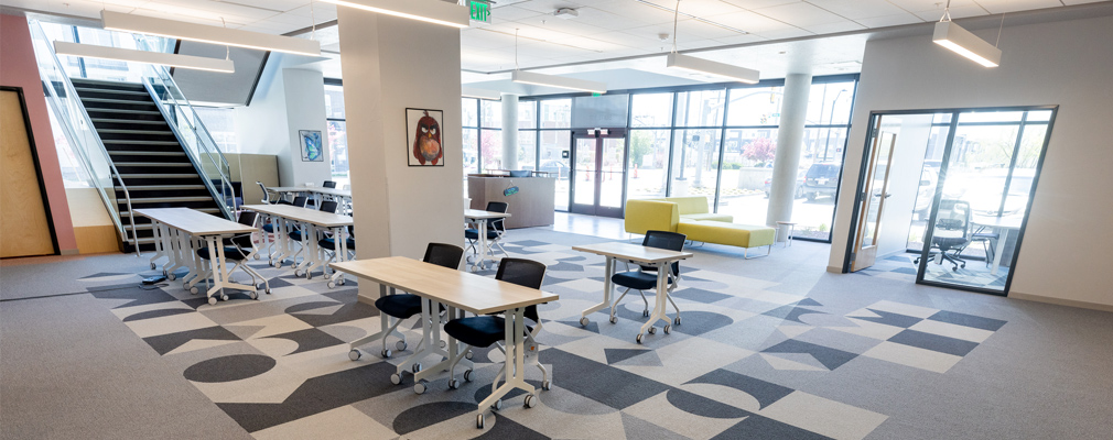 Photograph of desks and chairs in the open layout of the first floor of the NextWork Academy.