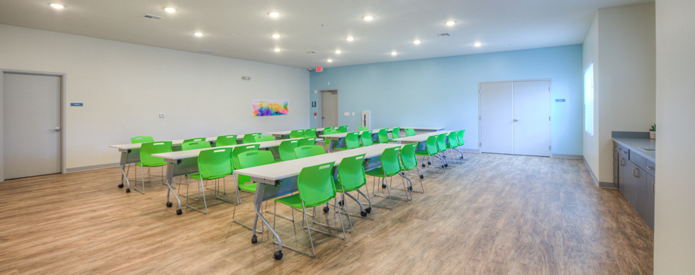A large room with three rows of tables and chairs.