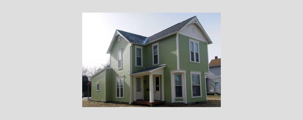 Photograph of two façades of a newly renovated two-story clapboard house.