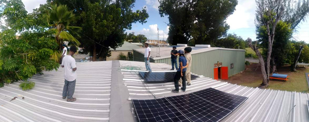 Workers installing solar panels on a roof.