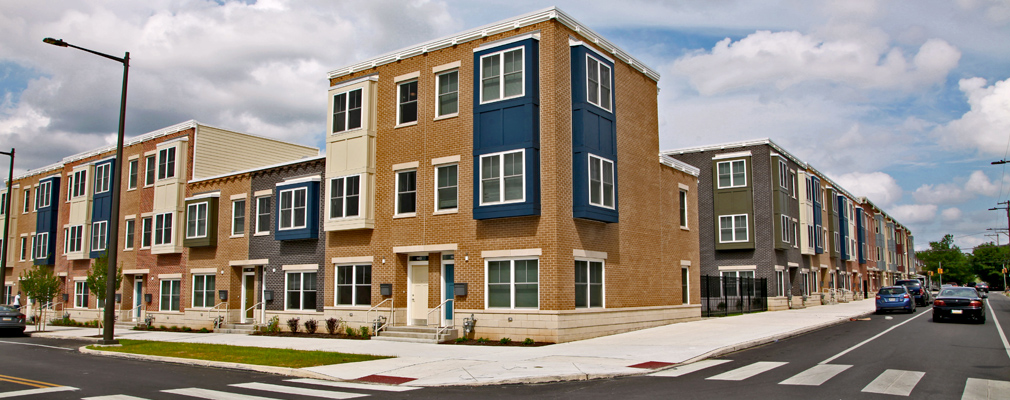 Corner view of low-rise apartment buildings from across the intersection.