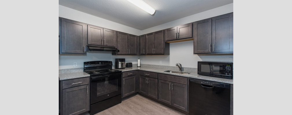 Kitchen with granite countertops and a microwave oven, range, dishwasher, and toaster.