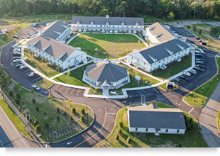 Aerial view of low-rise apartment buildings arranged around a pentagonal courtyard.