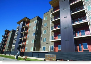 A five-story apartment building with a “Villagio” sign in the front at ground level.