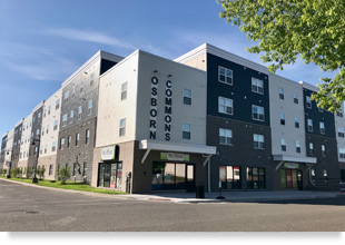 Two street façades of a four-story building with “Osborn Commons” written vertically above a first-floor retail space.