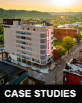 Low-angle aerial photograph of an eight-story building with a five-story blade sign that reads 