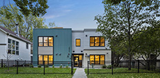Exterior image of a modern, two-story apartment building at dusk.