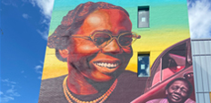 A mural on the façade of a four-story building.