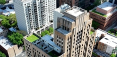 Aerial view of 24-story beige building surrounded by other buildings.