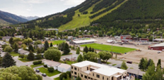 Aerial view of a three-story condominium building in a mountainous area.