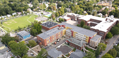 An aerial shot of the Founders Way development, which includes an L-shaped apartment building and several smaller standalone buildings.