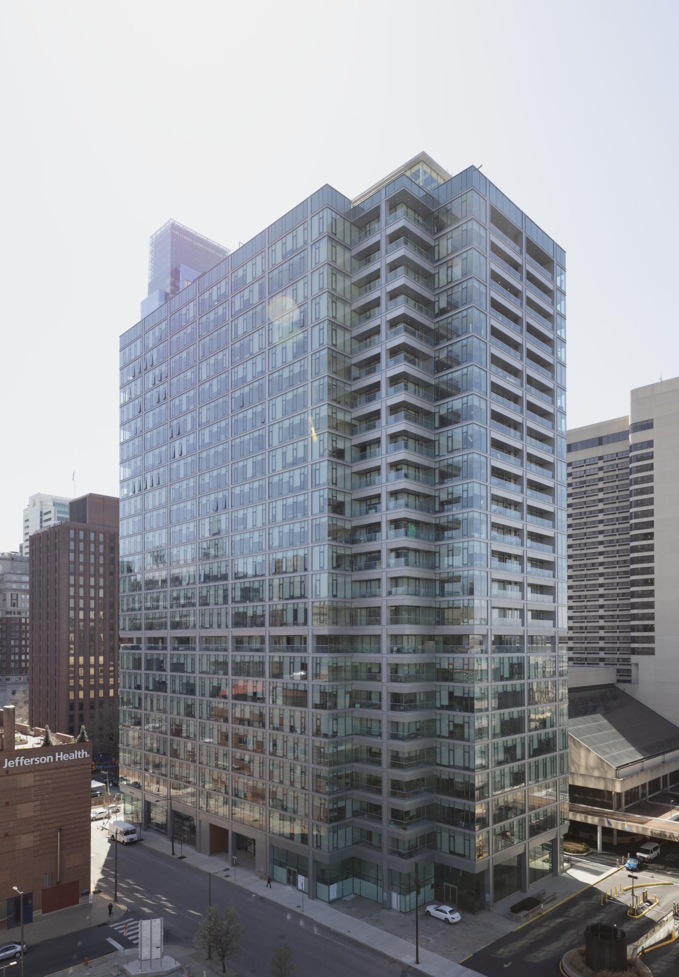 A tall multistory glass covered building.