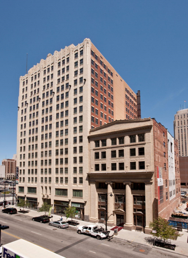 A tall multistory building with a shorter annex building.