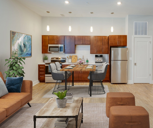 Apartment kitchen and dining area with living room seating in the foreground.