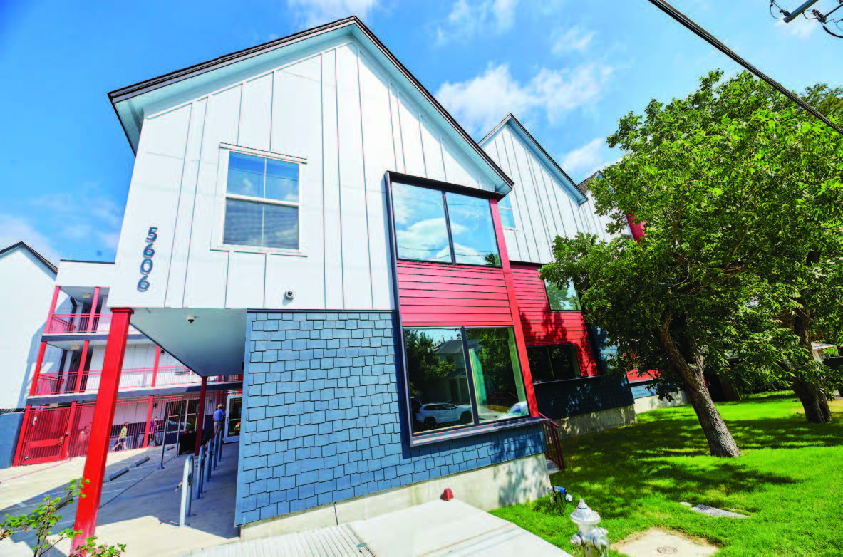 A colorful two-story building with windows in staggered walls.