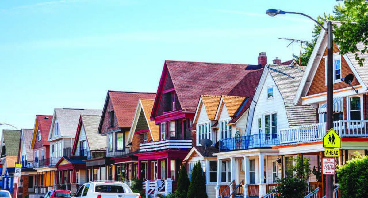  An angled view of two- and three-story residential buildings with a street light in the foreground.