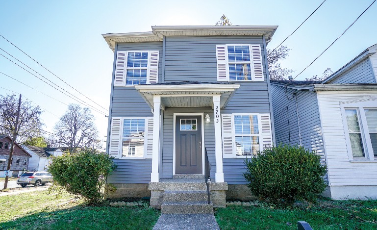 Front view of a two-story house with number "2202" on one of the porch columns.