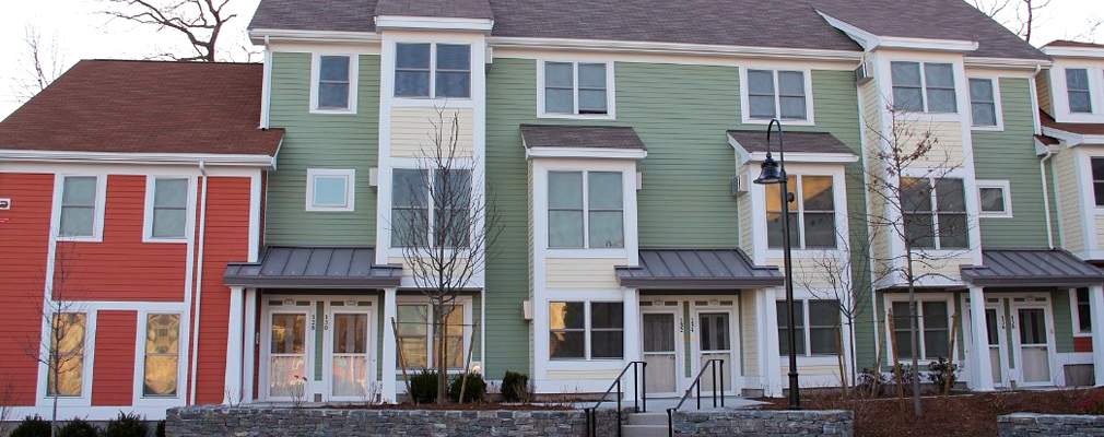 Photograph of the front façade of a newly constructed, multistory residential building.