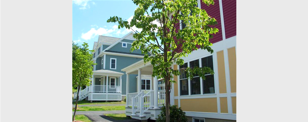 Photograph of two multistory residences with wood siding.