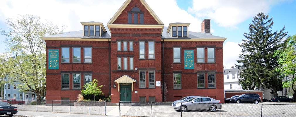 Photograph of the front façade of a two-story brick academic building, with a pedimented projection marking the entrance.