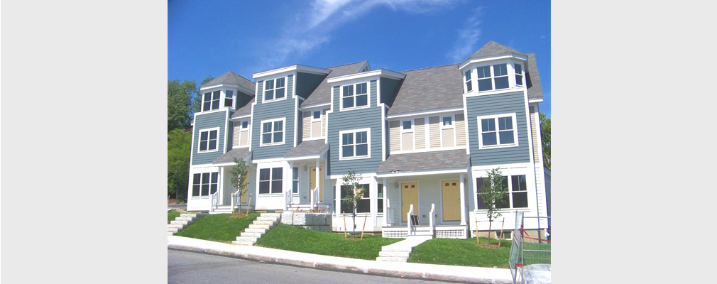 Photograph of a three-story multifamily building.