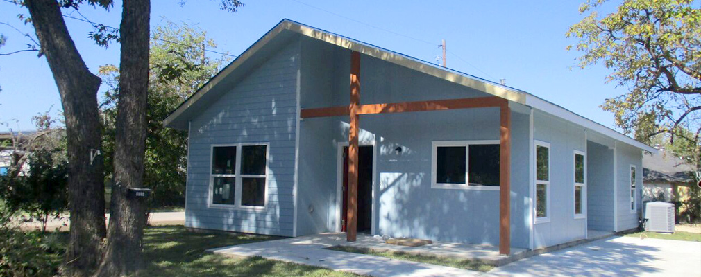 Photograph of the front façade of a newly constructed, one-story single-family house.