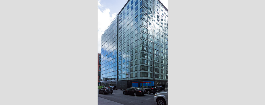 Photograph of the side façades of a highrise building with ground floor retail.