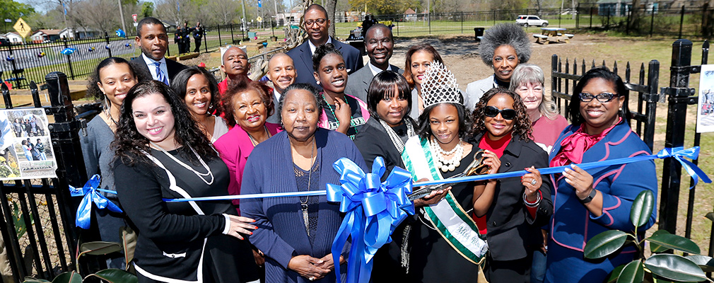 Photograph of 18 people participating in the garden’s ribbon-cutting ceremony.