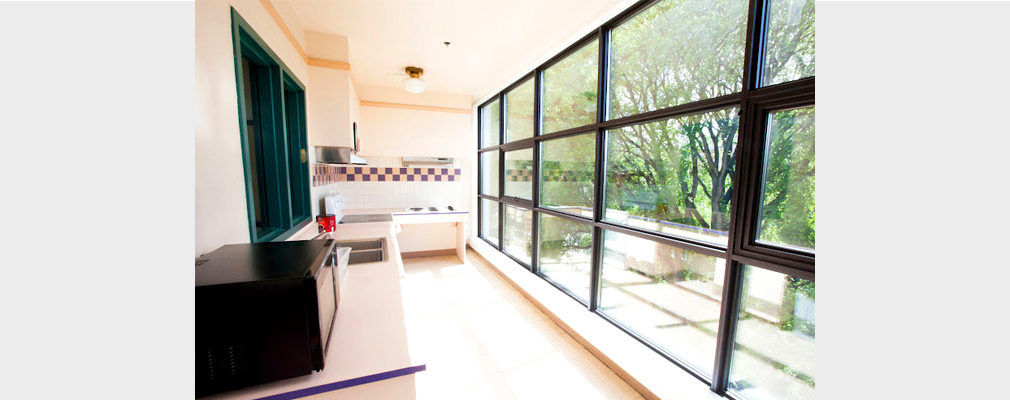 Photograph of a kitchen with one wall made of windows.