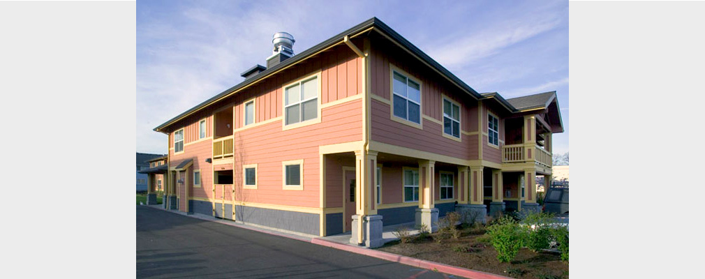 Photograph of the front and side façades of a two-story apartment building.
