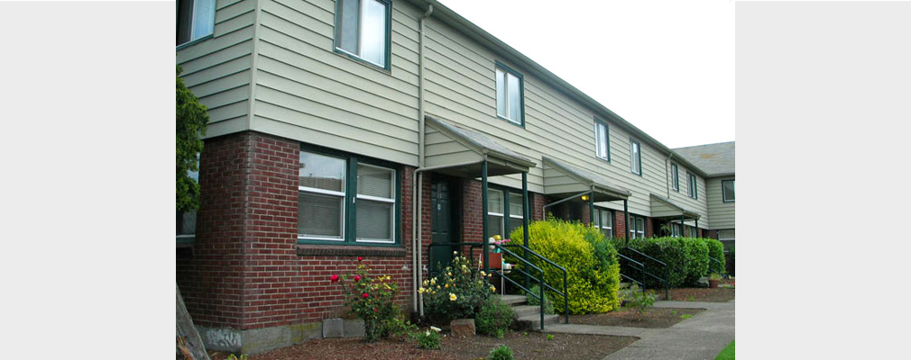 Photograph of the front façade of a row of 3 two-story townhouses.