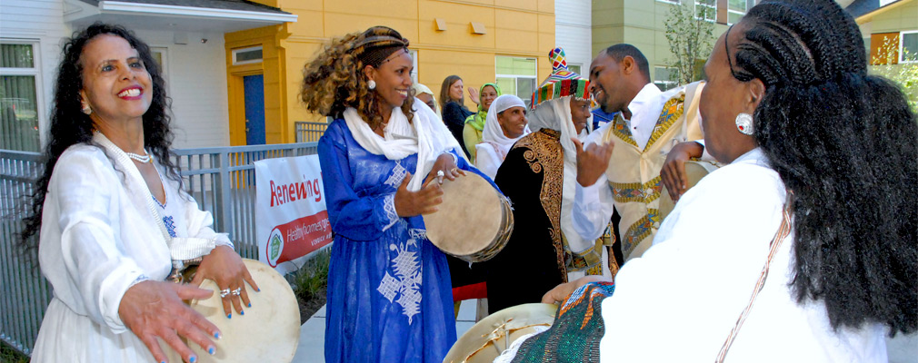 Photograph of Yesler Terrace residents and neighbors celebrating with traditional African kebero drums at the grand opening of a new apartment building.