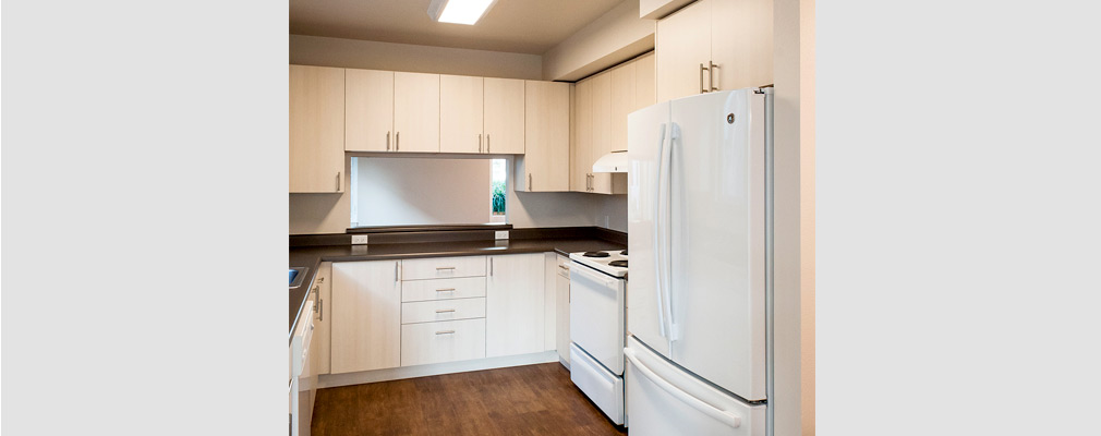 Photograph of a kitchen with appliances and cabinetry.