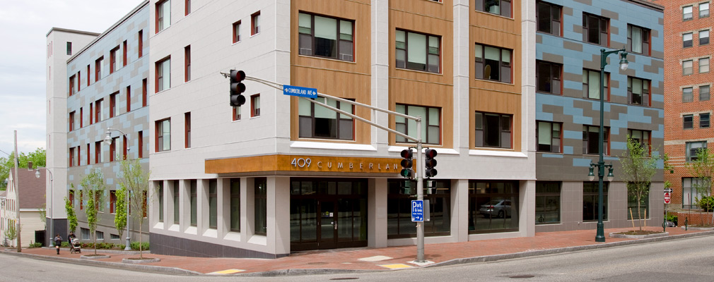 Photograph of the two street façades of a four-story apartment building. 