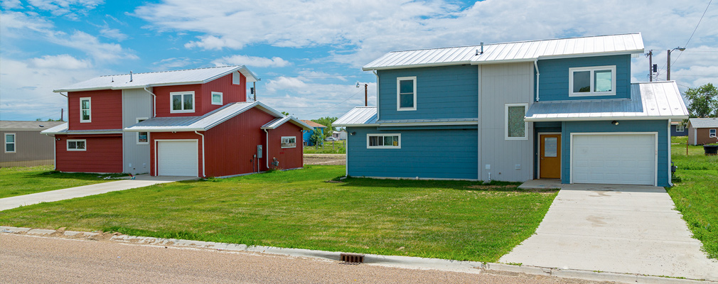 Photograph of the front façade of two two-story single-family detached houses.