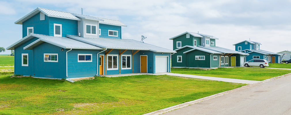 Photograph of three two-story single-family detached houses along a street.