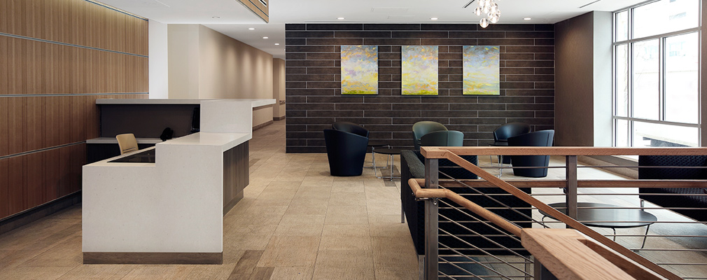 Interior photograph of the building’s lobby, including a reception desk and several tables with seating.