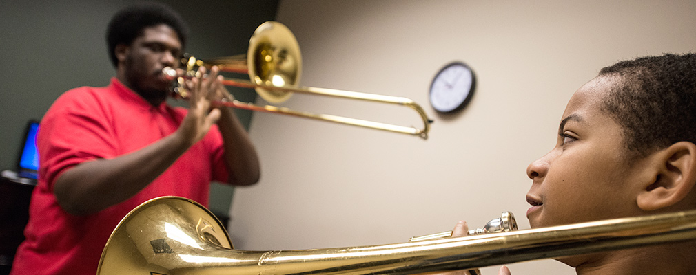 Two young boys play the trumpet.