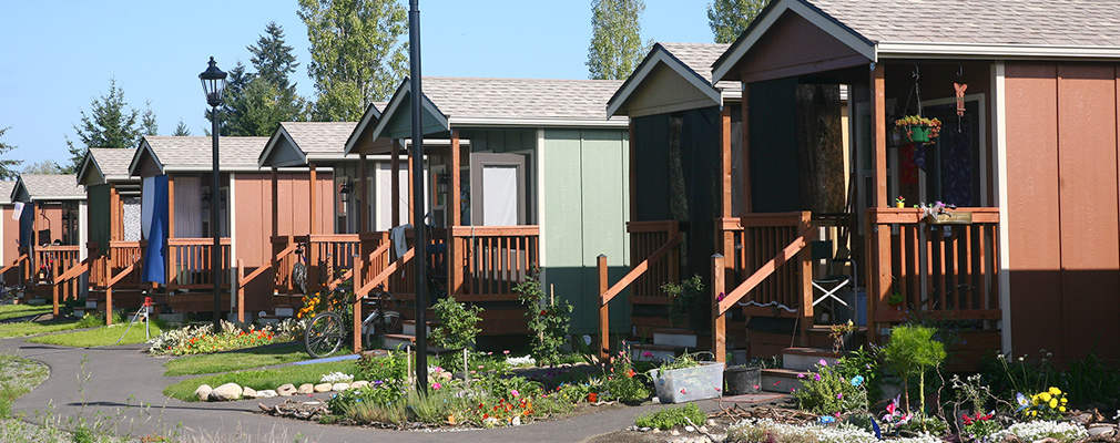 Photograph of nine cottages with a meandering walkway in front of them.