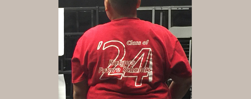 Photograph of the back of a boy wearing a t-shirt that reads, “Class of ’24, Rutgers Future Scholars.”