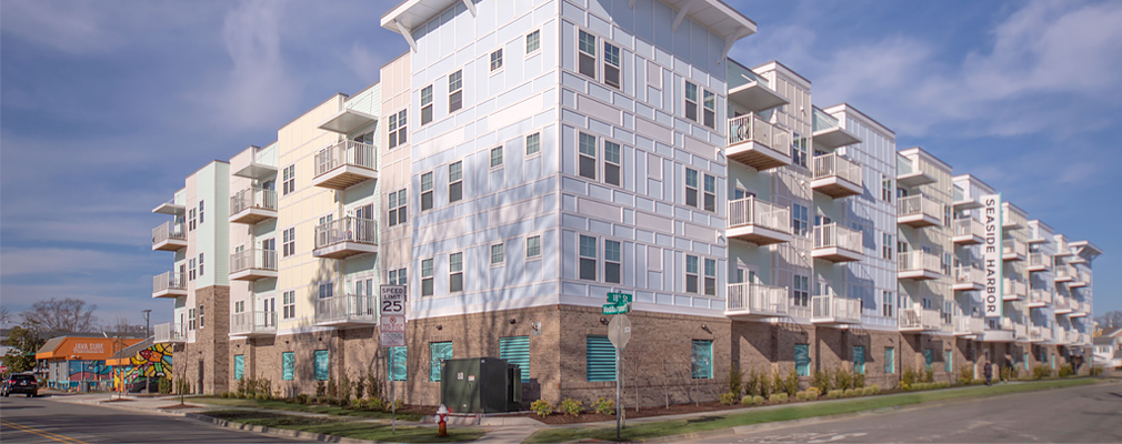 Photograph of two façades of a multistory apartment building. 